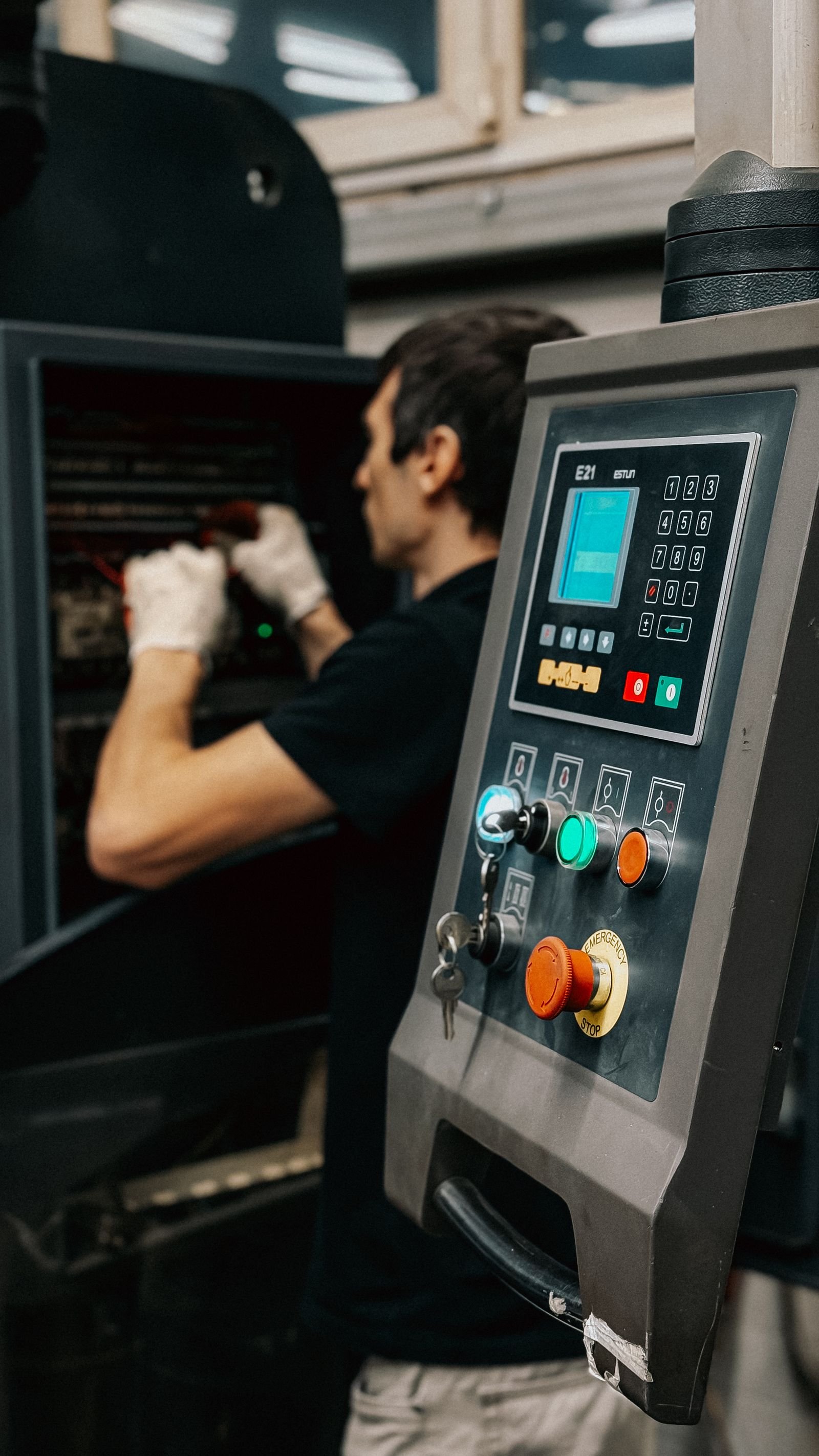 Technician operating a PLC control panel